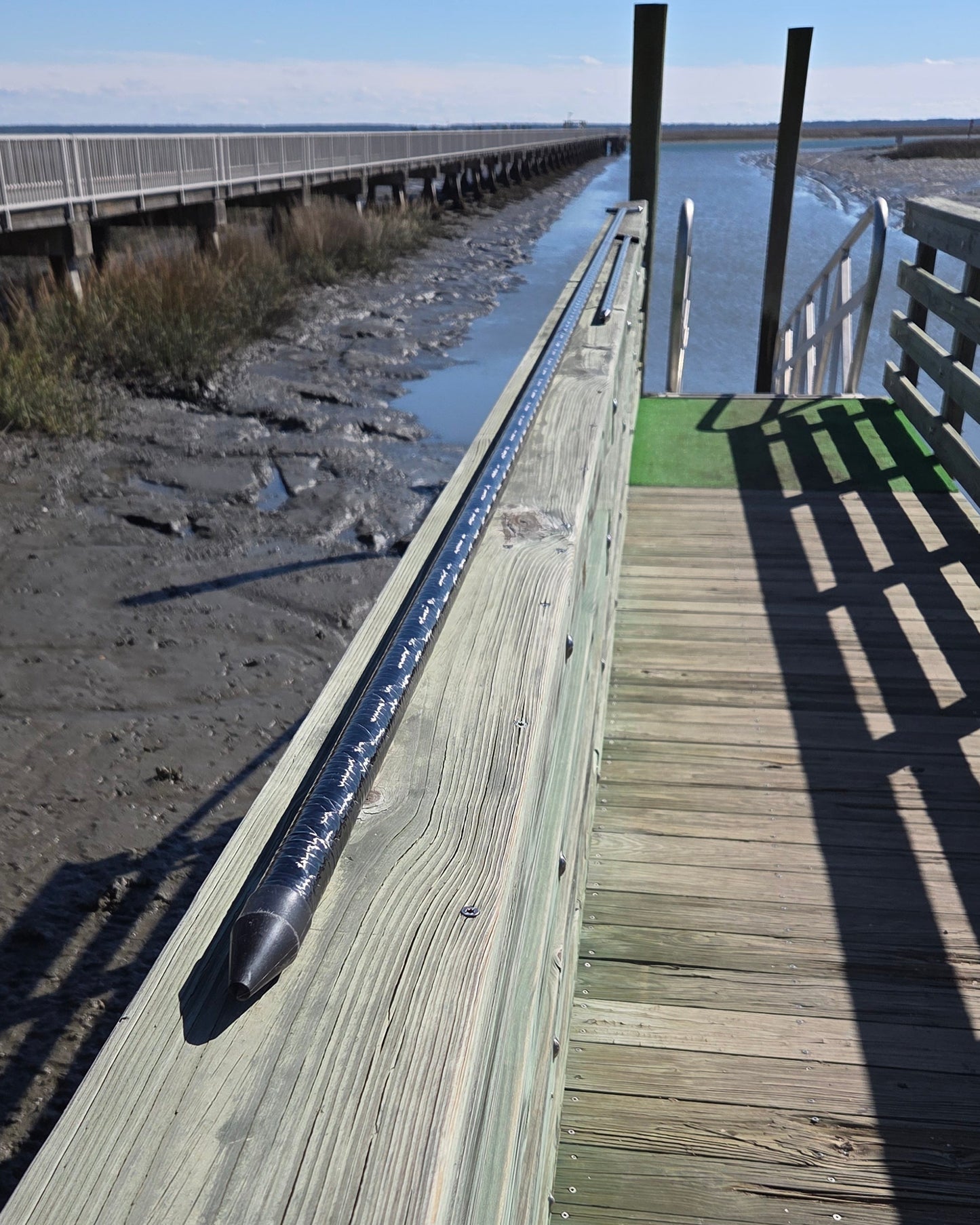 filament wound carbon fiber push pole on a dock by the marsh